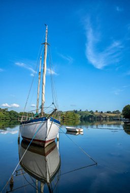 Dittisham, Devon, İngiltere yakınlarındaki bir körfezde demirli tekne.