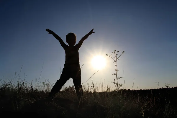 一个男孩的剪影与他的手在一个符文男子的姿态 孩子快乐地迎接日出的黎明 — 图库照片