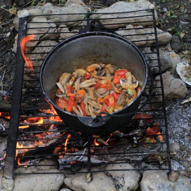 Alan koşullarında açık bir yangın bir tencerede pişirme