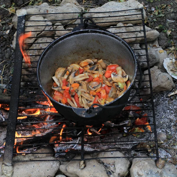 Alan koşullarında açık bir yangın bir tencerede pişirme