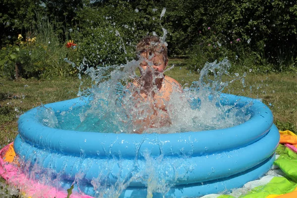 Pequeño Niño Baña Chorros Una Piscina Inflable — Foto de Stock