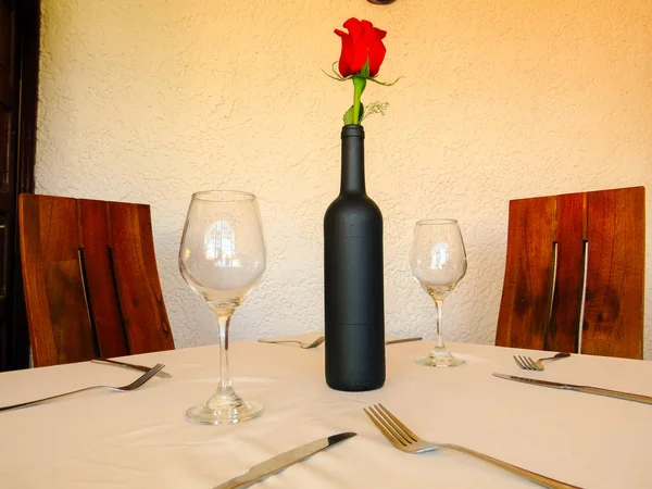 Elegant dining tables in restaurant with wine bottles and glasses.