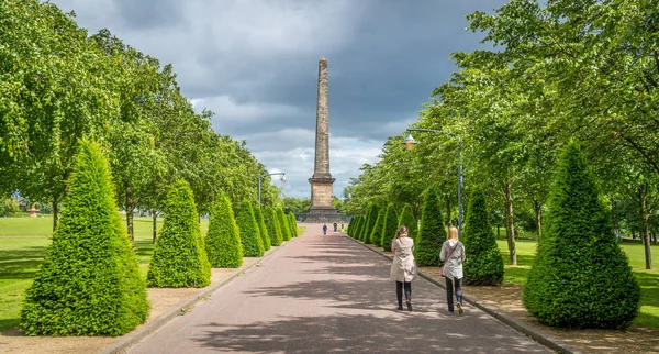Bir bulutlu yaz öğleden sonra Glasgow Green Park Nelson Anıtı 'na yol açan yolu, Iskoçya.