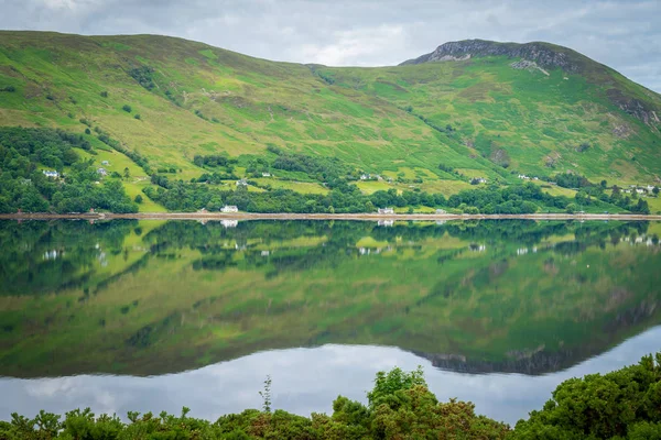 Mirror like reflections over Loch Broom in a cloudy morning. Ullapool, Scotland.