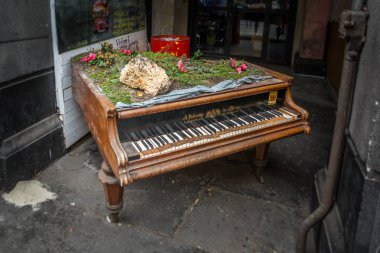Old decorated piano abandoned on the side of the street near Budapest main station. clipart