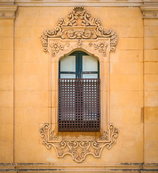 Old window in Noto with baroque decorations. Sicily, Italy.