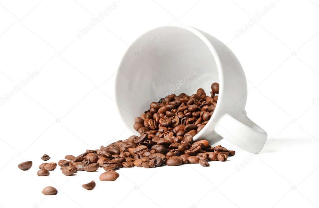 Coffee beans scattered from a fallen cup. White isolated background. Close-up.