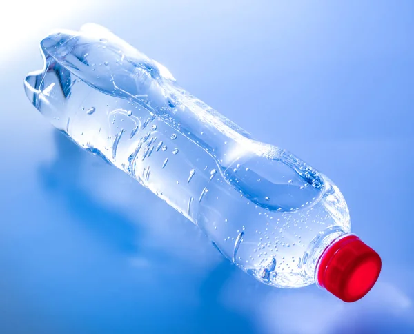 Mavi tonlarında bir şişe maden suyu. Close. Üst yan görünüm.