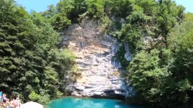 Mavi dağ gölü geniş bir lens aşağıda ağaçları ile kaplı kaya
