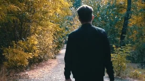 Cooler Mann bewegt sich auf einem Waldweg in die Ferne — Stockvideo