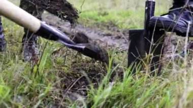 Üç askeri asker çernobil tarlasında kürekle toprakla mayın gömüyor.