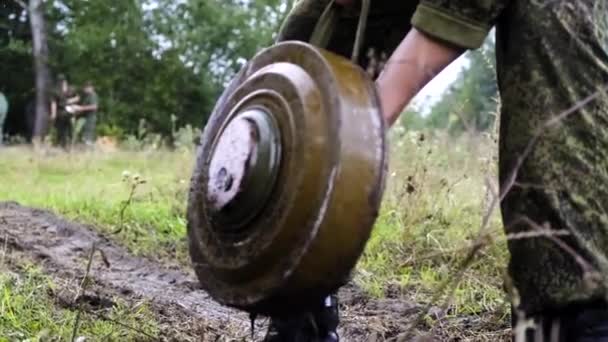 Wojskowy żołnierz obniża kopalni do ziemi w Czarnobylu pola zbliżenie — Wideo stockowe