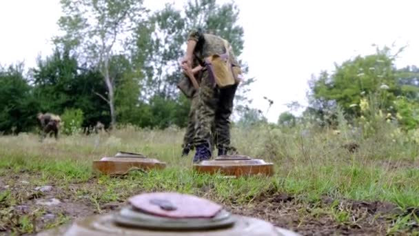 Varios cadetes militares de soldados cavan un agujero para enterrar tres minas antitanque en Chernobyl durante la lluvia — Vídeos de Stock