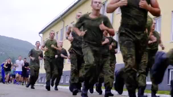 Athletic guys cadets on a morning run. Run in formation on the territory of a military base — Stock Video