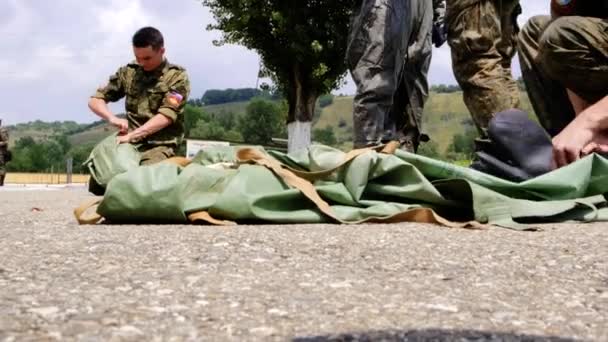 모스크바 - 7 월 28 일. 군인들은 호신용 양복을 가방에 넣어 모은다. 군 기지에서 표준을 통과하기 전에 몸을 푸는 일 — 비디오