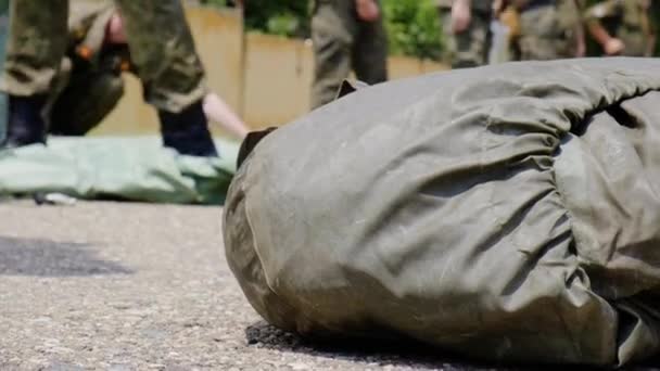 Moskou - 28 juli. Militaire cadetten verzamelen een beschermend pak in een tas. Opwarmen voor het passeren van normen op een militaire basis — Stockvideo