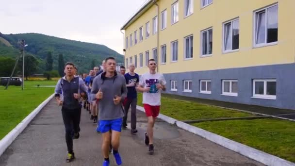 MOSCÚ 28 DE JULIO. Chicos deportistas cadetes en una carrera matutina. Ejecutar en formación en el territorio de una base militar. Calentar antes de pasar los estándares en una base militar — Vídeos de Stock