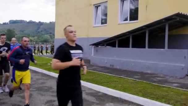 MOSCOW - JULY 28. Athletic guys cadets on a morning run. Run in formation on the territory of a military base. Warm up before passing standards at a military base — ストック動画