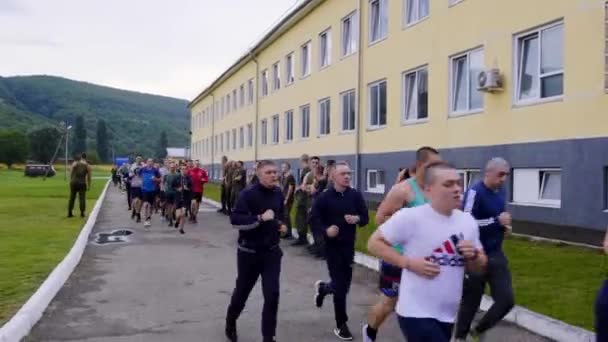 MOSCÚ 28 DE JULIO. Chicos deportistas cadetes en una carrera matutina. Ejecutar en formación en el territorio de una base militar. Calentar antes de pasar los estándares en una base militar — Vídeos de Stock