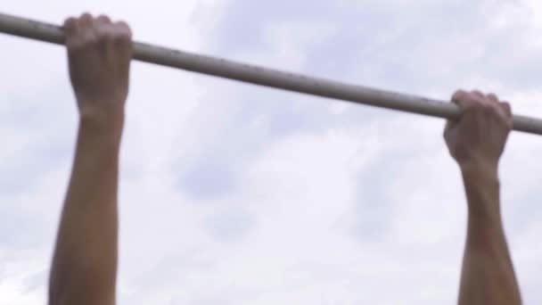 Moskou - 28 juli. Atletische man trekt zich op aan een horizontale balk in een militair kamp voor het krijgen van een bevredigend cijfer. Opwarmen voor het passeren van normen op een militaire basis — Stockvideo