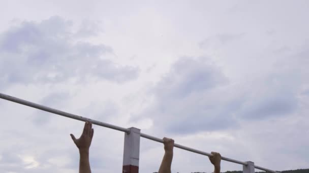 MOSCOW - JULY 28. Athletic guys pulls himself up on a horizontal bar in a military camp for getting a satisfactory mark. Warm up before passing standards at a military base — ストック動画