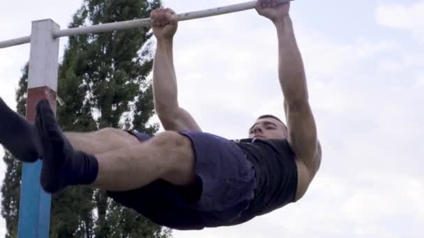 MOSCÚ 28 DE JULIO. Un tipo fuerte se dedica a entrenar en una barra horizontal en una base militar — Vídeos de Stock