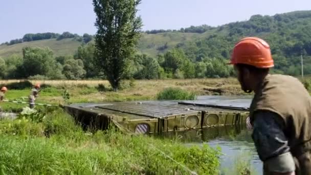 stock video MOSCOW - JULY 28. A military cadet soldier works on a pontoon bridge based on a KAMAZ truck while at a military secret base