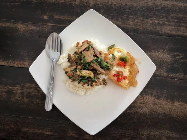 Rice topped with stir-fried duck and basil with fried egg