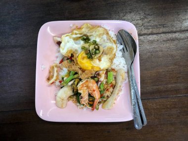 Pirinç kızarmış yumurta ile ateş deniz ürünleri ve fesleğen ile karıştırın tepesinde