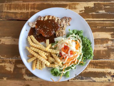 Kızarmış patates ve salata ile domuz biftek ahşap masada