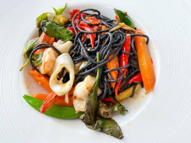 Baharatlı karışık deniz mahsullü siyah spagetti.