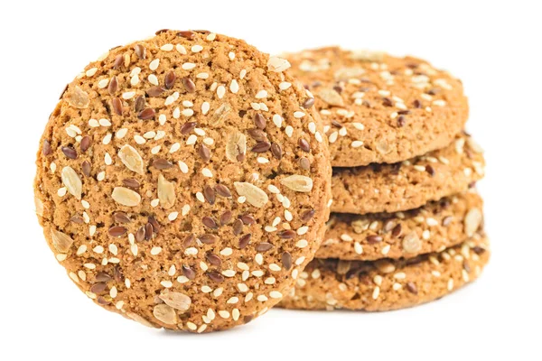 Yulaf ezmeli kurabiye ayçiçeği tohumu, keten tohumu ve susam tohumu ile serpilir. Beyaz bir arka plan üzerinde izole sağlıklı hamur işleri