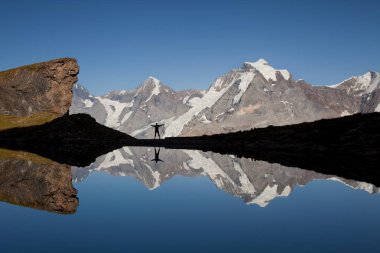 İsviçre Alpleri'nde duran kadın silueti, Murren bölgesinde, Eiger, Monch ve Jungfrau dağlarına bakan Grauseewli Gölü,Bern Kantonu, Lauterbrunnen, İsviçre'ye yansıyan