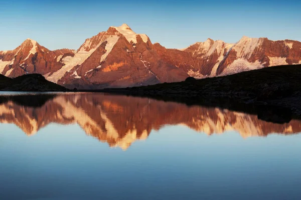 Scenic view of mountains reflecting in water