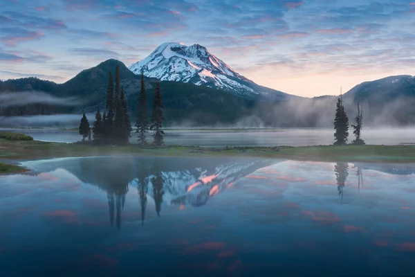 scenic view of landscape with sky reflecting in lake with trees in background