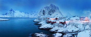 Kışın ışıklı evlerin ve dağların manzara görünümü