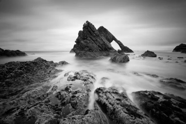 Scenic view of rocks and sea, black and white