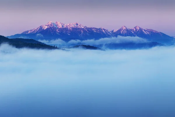 太陽の光の中の雲の中の山々の風光明媚な眺め — ストック写真