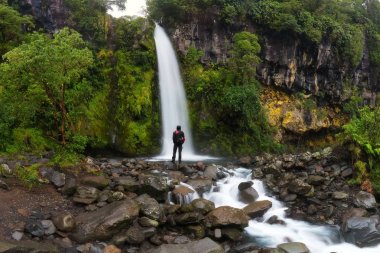 Yaz aylarında şelaleye bakan adamın manzara görünümü