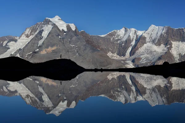 Scenic view of mountains reflecting in water