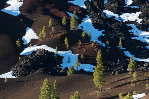 The Painted Dunes as seen from the top of the Cinder Cone in Lassen Volcanic National Park, on a sunny day, featuring the lava bed, bare, rugged terrain, and curves, spring and summertime