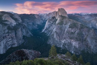 Yarım Kubbe ve Yosemite Vadisi Yosemite Milli Parkı ağaçlar ve kayalar ile renkli gün batımı sırasında. Yosemite en popüler bakış açısında California, Abd Güneşli gün. Güzel manzara arka plan