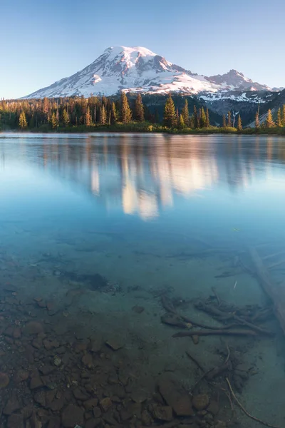 A reflection of snow capped Mount Shasta in a clear water in lake at sunrise in California State, USA. Mount Shasta is a volcano at the southern end of the Cascade Range in Siskiyou County
