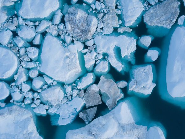 Icebergs drone aerial image top view - Climate Change and Global Warming. Icebergs from melting glacier in icefjord in Ilulissat, Greenland. Arctic nature ice landscape in Unesco World Heritage Site