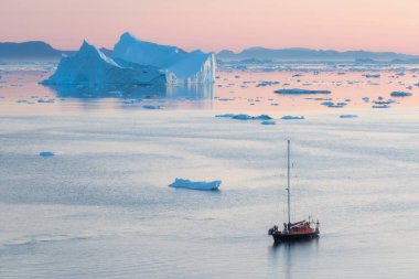 Grönland icefjord buzdağları ile Arktik doğa manzara gece yarısı güneş günbatımı / ufukta gündoğumu ile. Gece yarısı sezonunda erken sabah yaz alpenglow. Ilulissat, Batı Grönland.