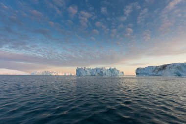 Batı Grönland 'daki Disko Körfezi' nde farklı şekillerde devasa buzdağları var. Kaynağı Jakobshavn buzulu. Bu küresel ısınma olgusunun ve buzların erimesinin bir sonucudur. 