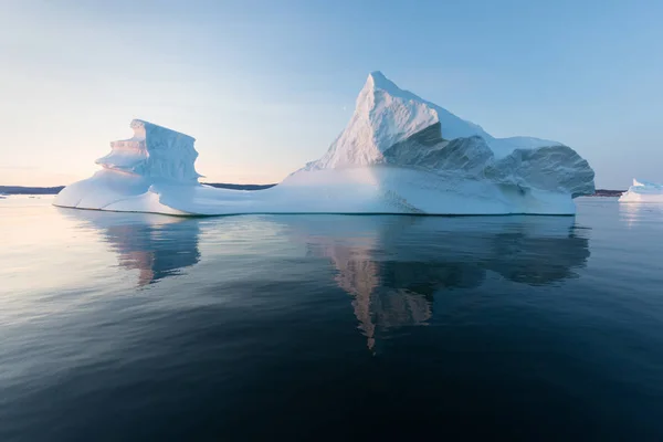 西グリーンランドのディスコ湾には さまざまな形の巨大な氷山があります 彼らの情報源はヤコブスハーン氷河である これは地球温暖化と氷の壊滅的な融解の現象の結果です — ストック写真