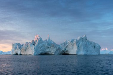 Ilulissat yakınlarındaki Icefjord 'un ağzındaki siste mahsur kalmış buzdağları. Grönland 'ın doğa ve manzaraları. Gemide buzların arasında seyahat et. Küresel ısınma fenomeni. Gün batımında sahil. 
