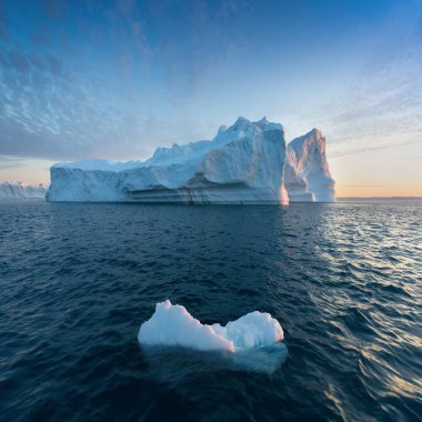 Ilulissat yakınlarındaki Icefjord 'un ağzındaki siste mahsur kalmış buzdağları. Grönland 'ın doğa ve manzaraları. Gemide buzların arasında seyahat et. Küresel ısınma fenomeni. Gün batımında sahil. 