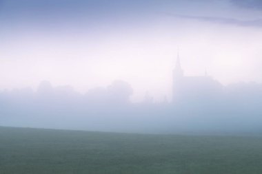 Çek Cumhuriyeti, Bohemya Cenneti 'ndeki Trosky kalesinin kalıntıları. Harabeler, odunsu tepedeki yıkılmış iki kuleden oluşuyor. Sisli atmosferi olan sabah manzarası
